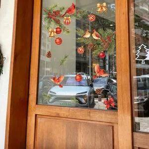 Festive Christmas window stickers featuring red cardinals and pine branches on a glass door.