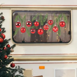 Detail view of festive Christmas window stickers with red ornaments and pine needles.