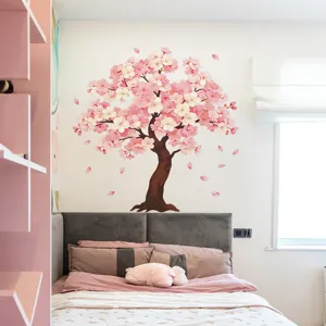 Dettaglio di un adesivo murale a forma di ciliegio rosa applicato sopra la testiera del letto