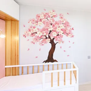 Grande adesivo murale albero di ciliegio rosa applicato in una cameretta accogliente.