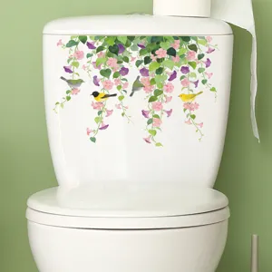 Detailansicht von Blumenreben und Vogel-Wandstickern auf einem weißen Toilettentank.