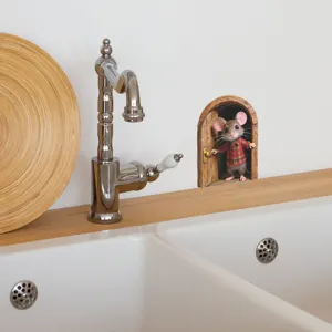 Detail of 3D mouse wall sticker applied on white bathroom wall next to silver faucet