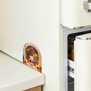 Detail of a 3D Christmas mouse hole wall sticker applied to a white kitchen cabinet base