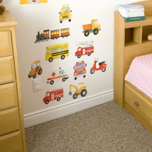 Detail of cartoon vehicle wall stickers featuring colorful trucks and buses in a kid's room.