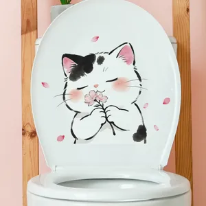 Macro view of a cute cartoon cat sticker with pink petals on a white toilet lid
