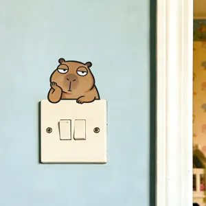 Niedlicher Cartoon-Wasserschwein-Wandaufkleber über einem weißen Lichtschalter auf blauer Wand