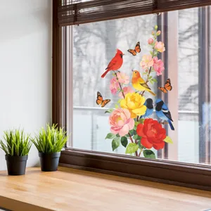 Detailed view of colorful cardinal and floral window stickers on a glass surface.