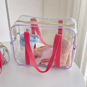 Vue détail sac cabas PVC transparent, organisateur de plage et de voyage avec des poignées roses.