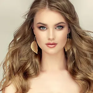Elegant natural gold leaf dangle earrings shown on a model for a sophisticated look