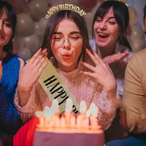 Close-up of girl wearing golden Happy Birthday sash and headband at party