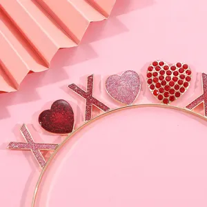 Close-up of pink glittery XOXO and rhinestone heart details on a Valentine's Day headband