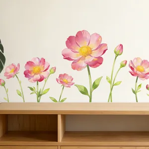 Detail of watercolor poppy flower wall stickers in pink and green on a white wall.