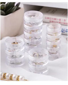 Vue de détail des pots de rangement empilables en plastique transparent pour petits bijoux.