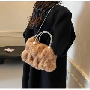 Side view of a brown faux fur handbag with pearl handles and silver chain strap