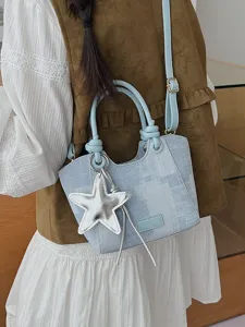 Stylish denim blue bucket bag featuring a silver star charm and adjustable shoulder strap