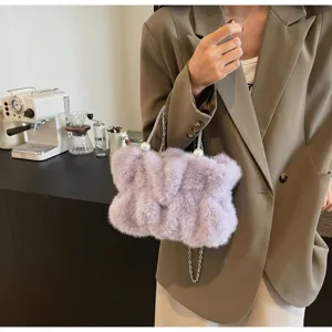 Close-up of lavender faux fur handbag featuring pearl accents and silver chain strap