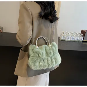 Model wearing a stylish light green faux fur bag with pearl handle and chain strap detail