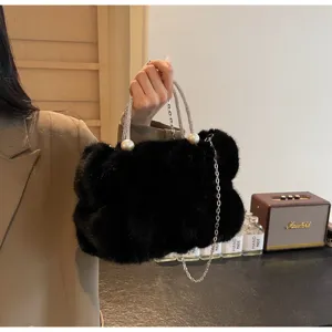 Detailed view of luxury black faux fur handbag with pearl and chain handle