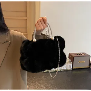 Chic black faux fur bucket bag with pearl details and a silver chain strap for winter.
