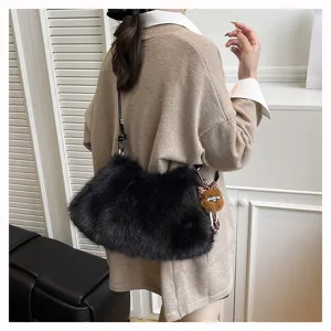 Detailaufnahme einer stilvollen schwarzen Kunstfelltasche mit einem süßen braunen Anhänger