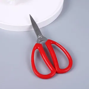 Detailed view of red handled stainless steel household scissors, sharp blade for crafts.