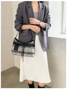 Mujer a la moda con un bolso tote de punto a rayas en un atuendo de oficina informal