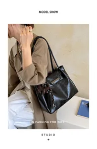Detailansicht einer großen schwarzen Ledertasche mit Vintage-Falten und Anhängern.