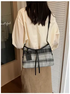 Bolso tote de lona con rayas blancas y negras de estilo vintage usado por una modelo