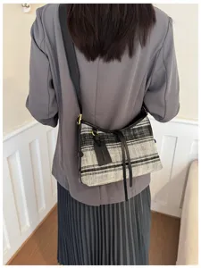 Detalle de un bolso de lona con rayas blancas y negras estilo retro en una modelo