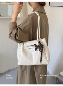 Große beige Tragetasche aus weichem Leder mit braunem Schmetterlingsanhänger Detail