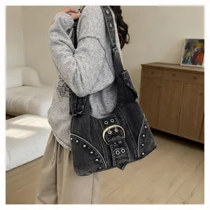 Side view detail of vintage washed denim hobo bag featuring punk rivets and buckle