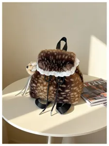 Plush leopard print backpack with white lace trim and cute bear charm shown on a white table
