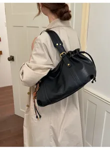 Dettaglio di una borsa a secchiello nera vintage in morbida ecopelle con coulisse