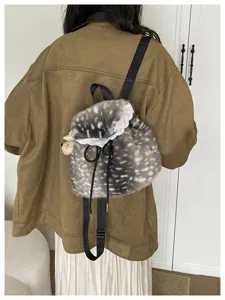 Back view of a plush fawn-pattern backpack with white lace trim and black straps.