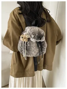 Detailed back view of a plush furry lace-trim backpack styled on a model in a brown jacket