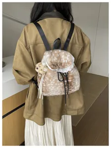 Close-up of a fluffy spotted faux fur backpack with white lace trim and teddy bear charm