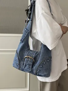 Vintage washed denim underarm bag with punk rivets and large belt buckle for women.