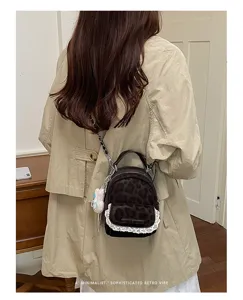 Detalle de mini mochila de leopardo con encaje y lazo decorativo