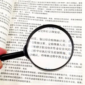 Handheld optical magnifying glass close-up detail showing clear text magnification performance.