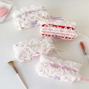 Group of quilted floral pencil cases with lace trim in pastel cream colors
