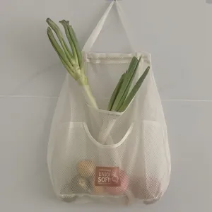 Large white mesh hanging storage bag for kitchen vegetables, breathable wall-mounted net pocket.