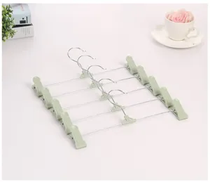 Antislip metalen broekhangers met groene kunststof clips voor broeken, rokken en kleding.