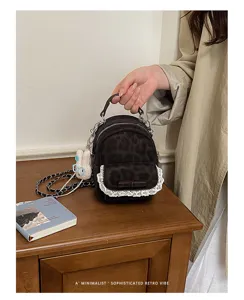 Primer plano de mini mochila de leopardo con encaje delicado y detalle de lazo.