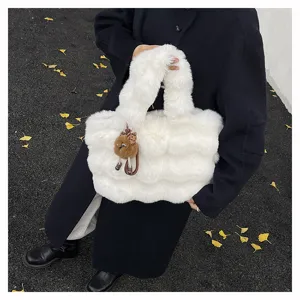 Nahaufnahme der weißen flauschigen Kunstpelz-Handtasche mit süßem Plüsch-Anhänger