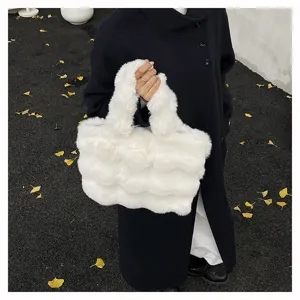 Detailansicht einer weißen, flauschigen Kunstpelz-Handtasche, die ein Modell trägt