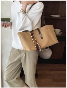 Bolso tote grande de lona caqui con correas de cuero y borla decorativa en modelo