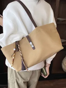 Bolso tote de lona artístico con correas de cuero y borlas decorativas al hombro