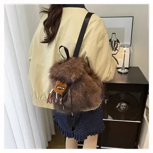 Moderne Frau mit großem braunem Kunstpelz-Rucksack in einer gemütlichen Innenaufnahme