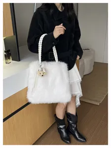 Modell mit eleganter weißer Kunstfelltasche mit geflochtenen Griffen im Interieur