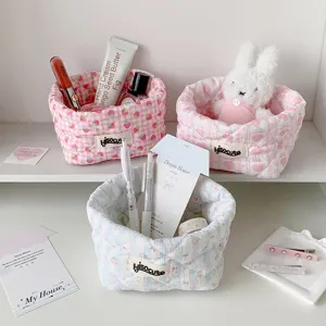 Detailed close-up showing three quilted fabric storage baskets on an organized white desk surface